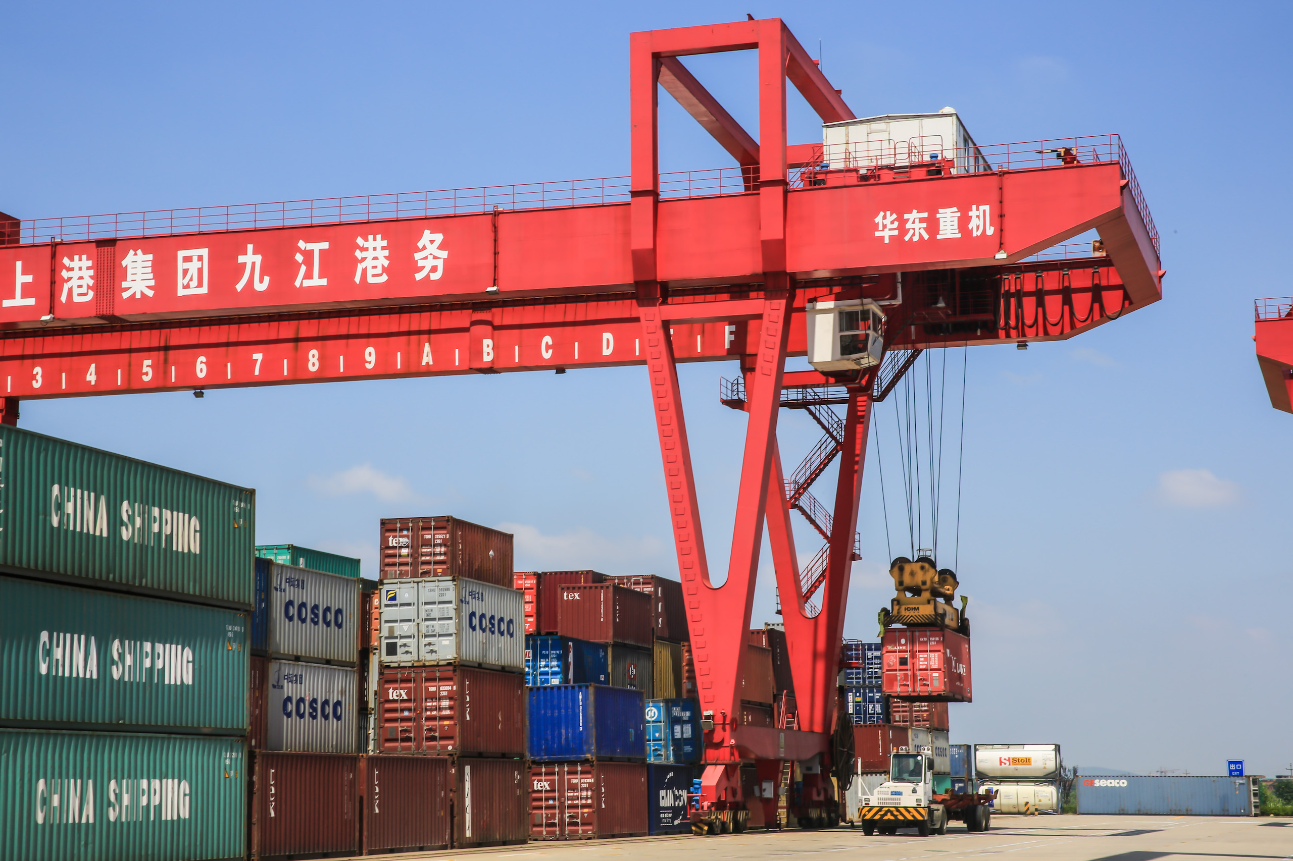 Shanghai, China - June 9, 2021: Workers operate automated crane equipment to load and unload containers at the foreign trade terminal of SIP Jiujiang Port. In the first half of 2021, the total value of China's foreign trade increased by 27.1% year on year.