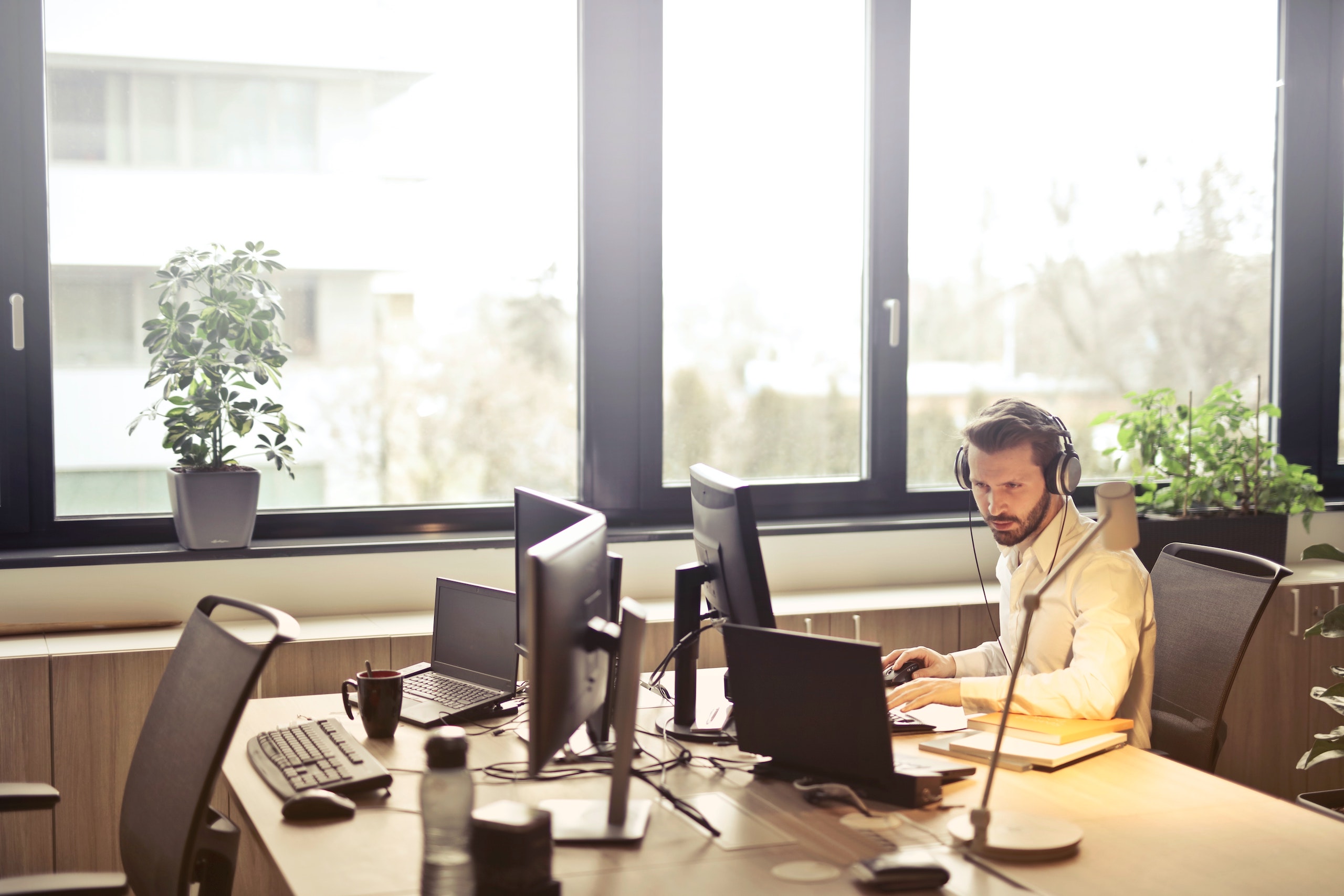 man working at computer with headset on