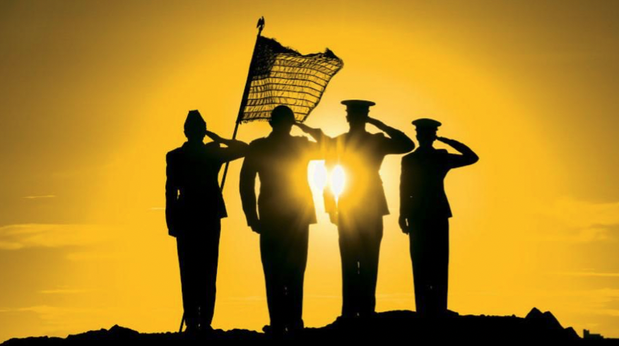 U.S. Service members silhouetted against a yellow sunset.