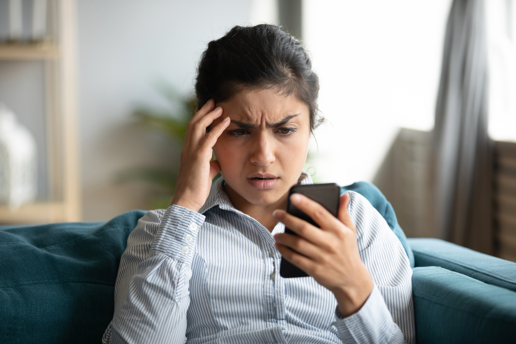 Woman looks concerned while holding phone 
