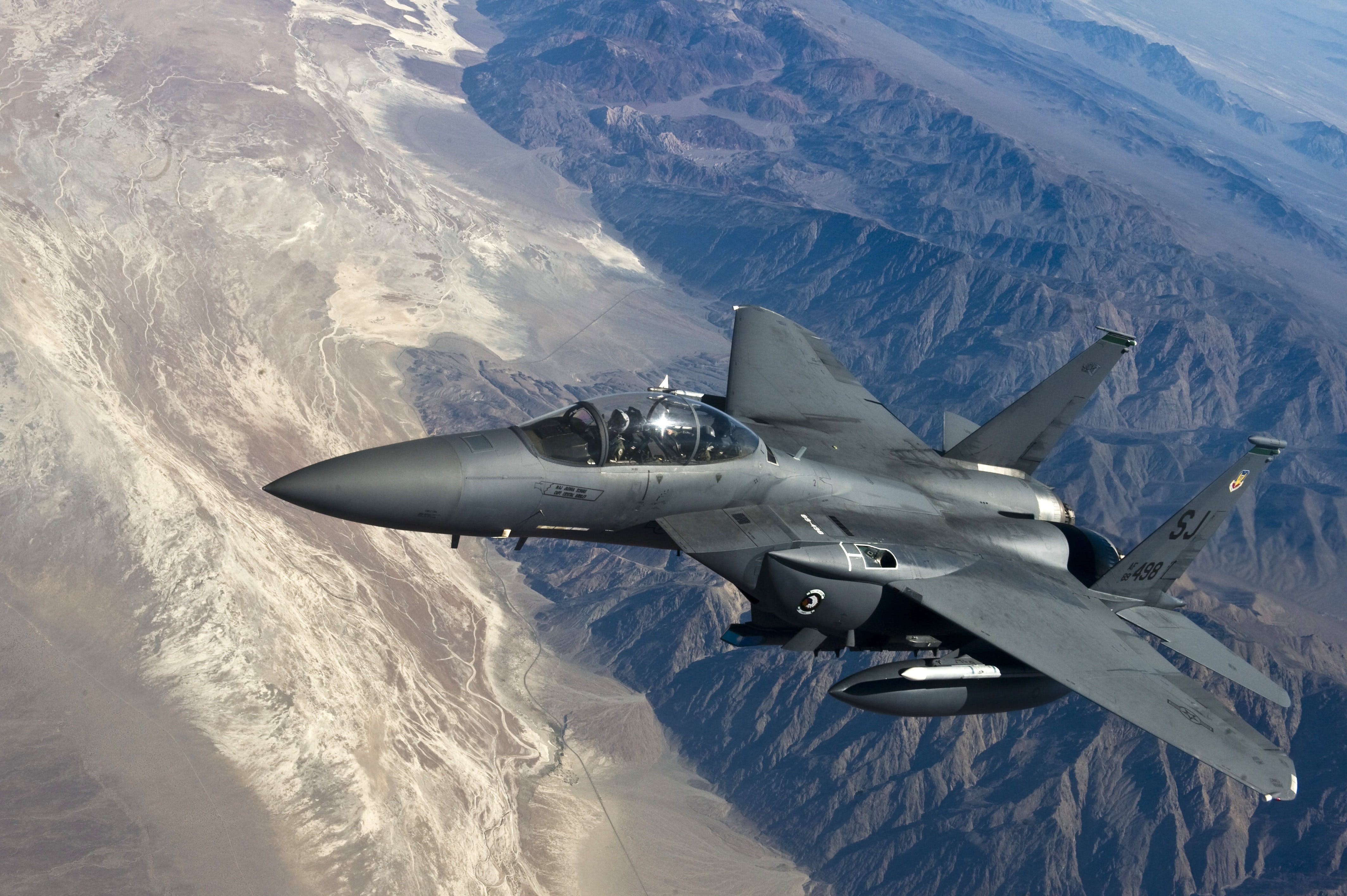 Military plane flying over canyon.