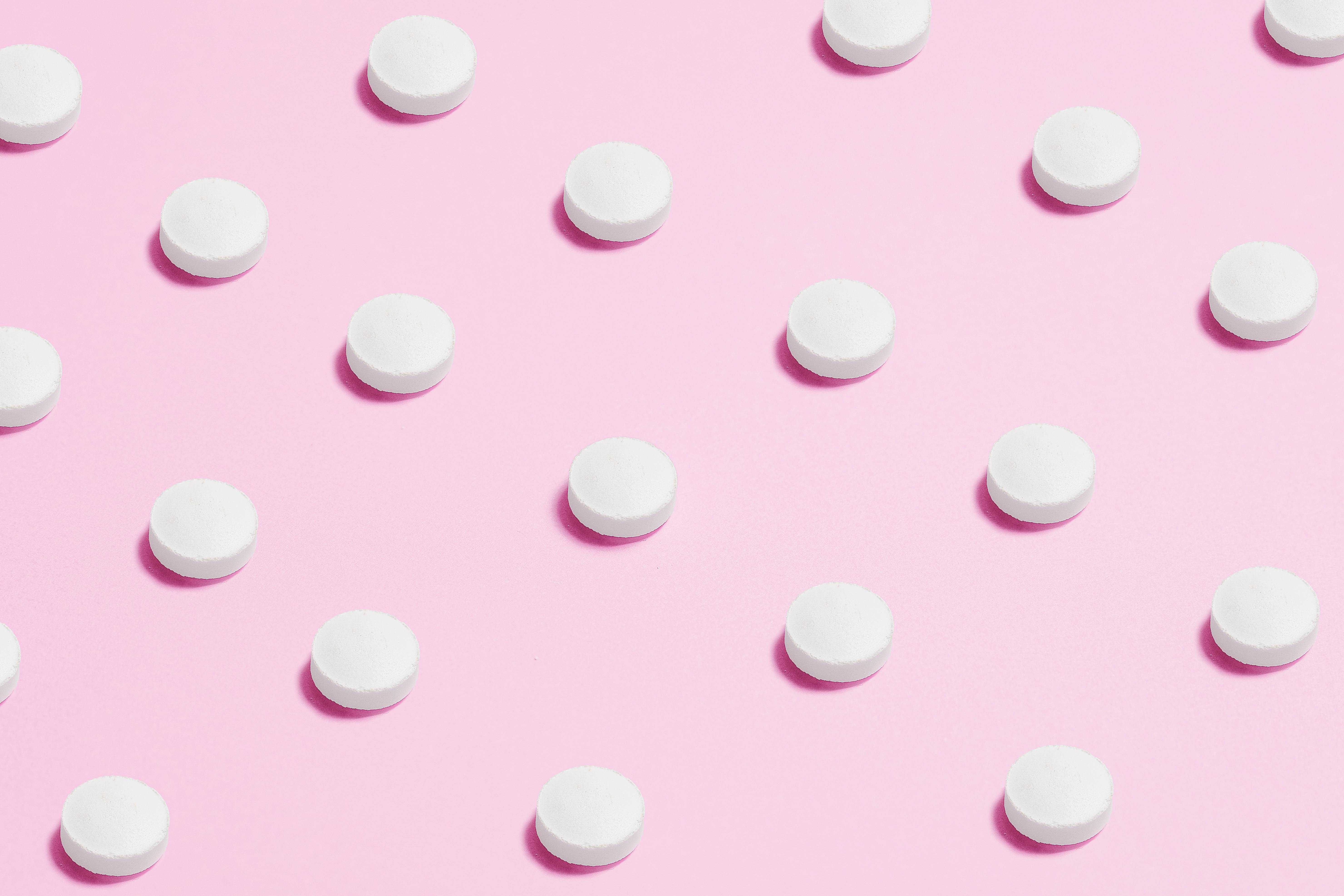 Pills on pink background.