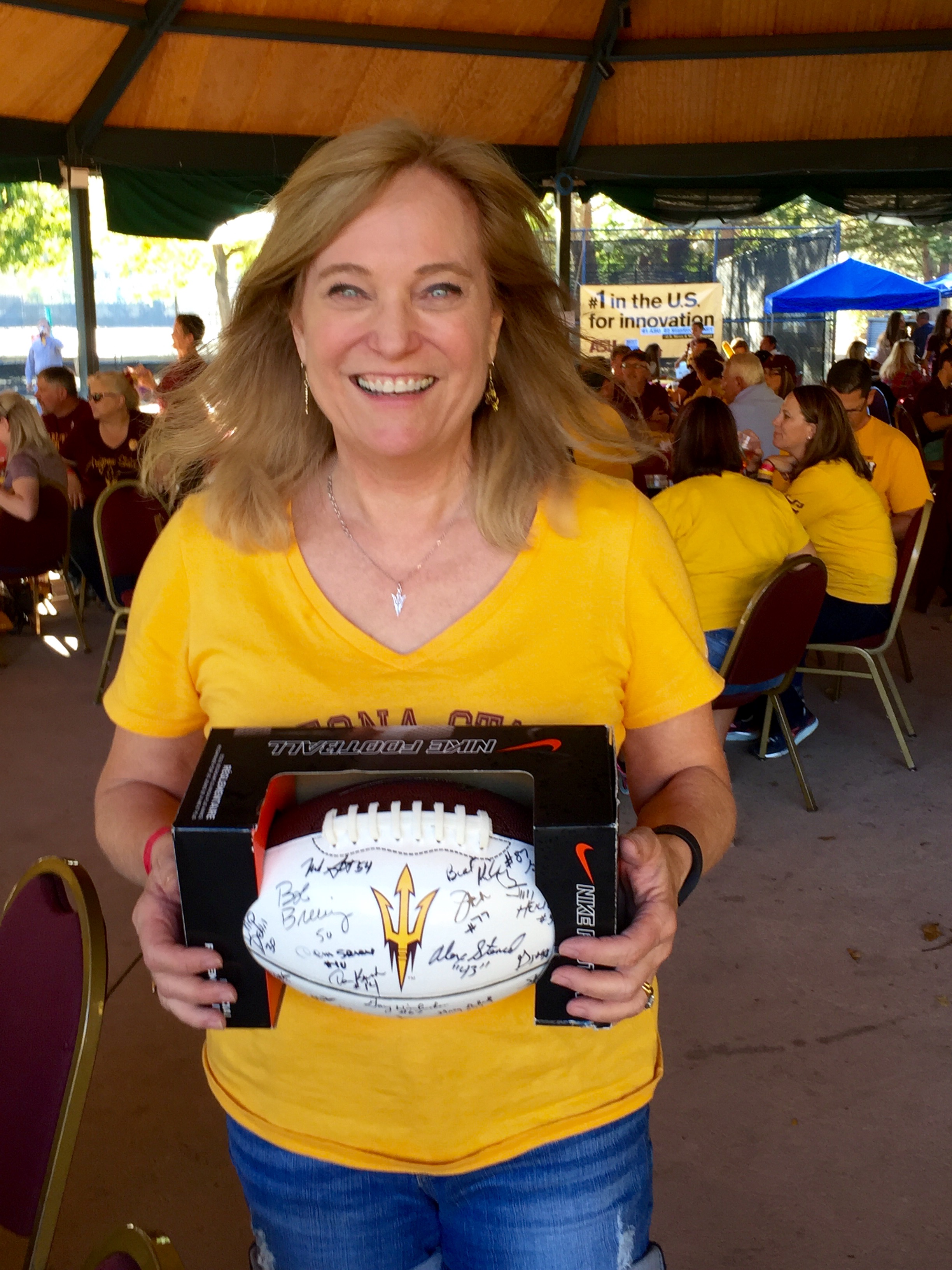 Andra Vallee Van Essen (BS Business Administration '79) holding an autographed ASU football