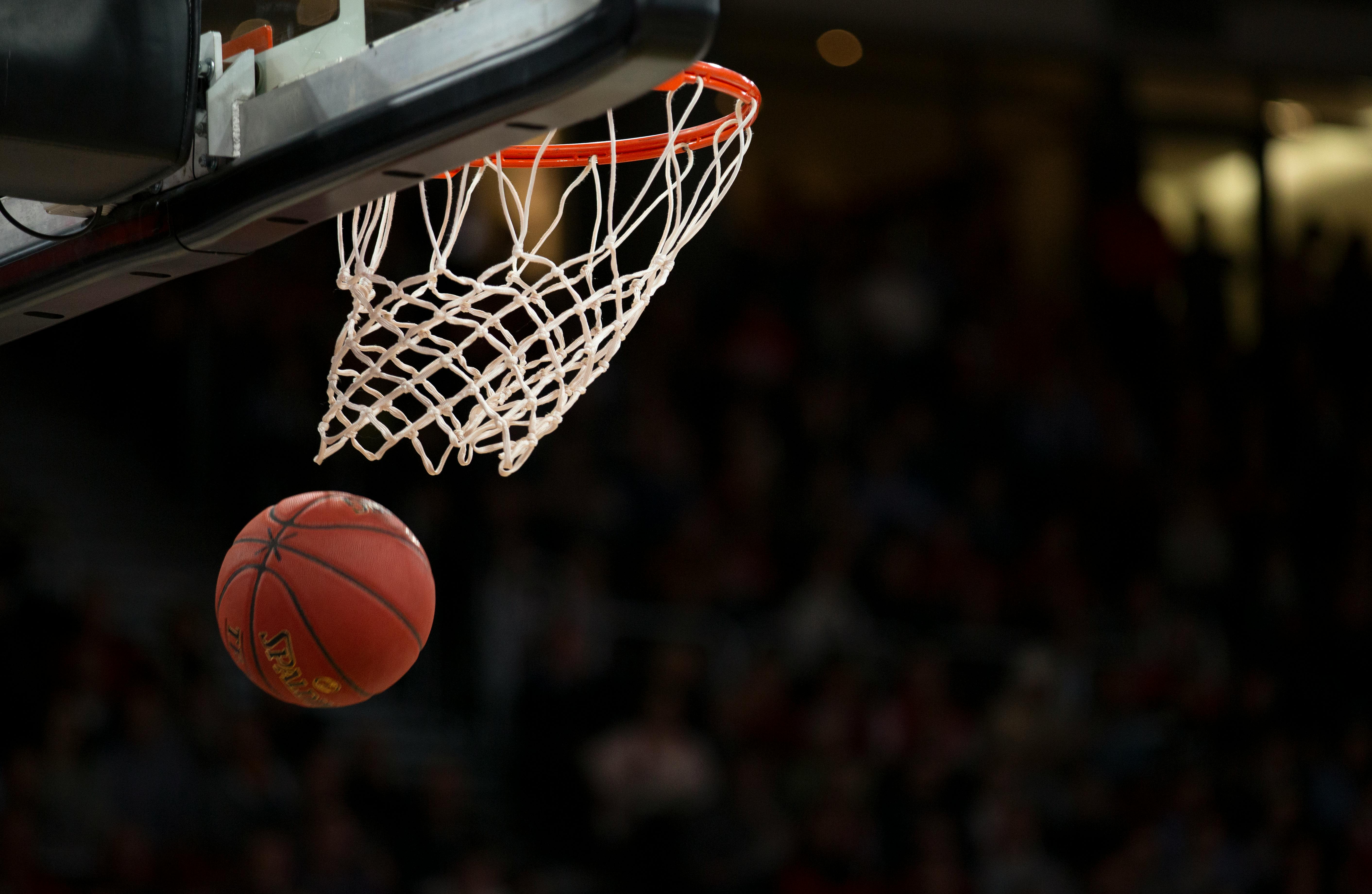 A basketball flying through a basketball hoop.