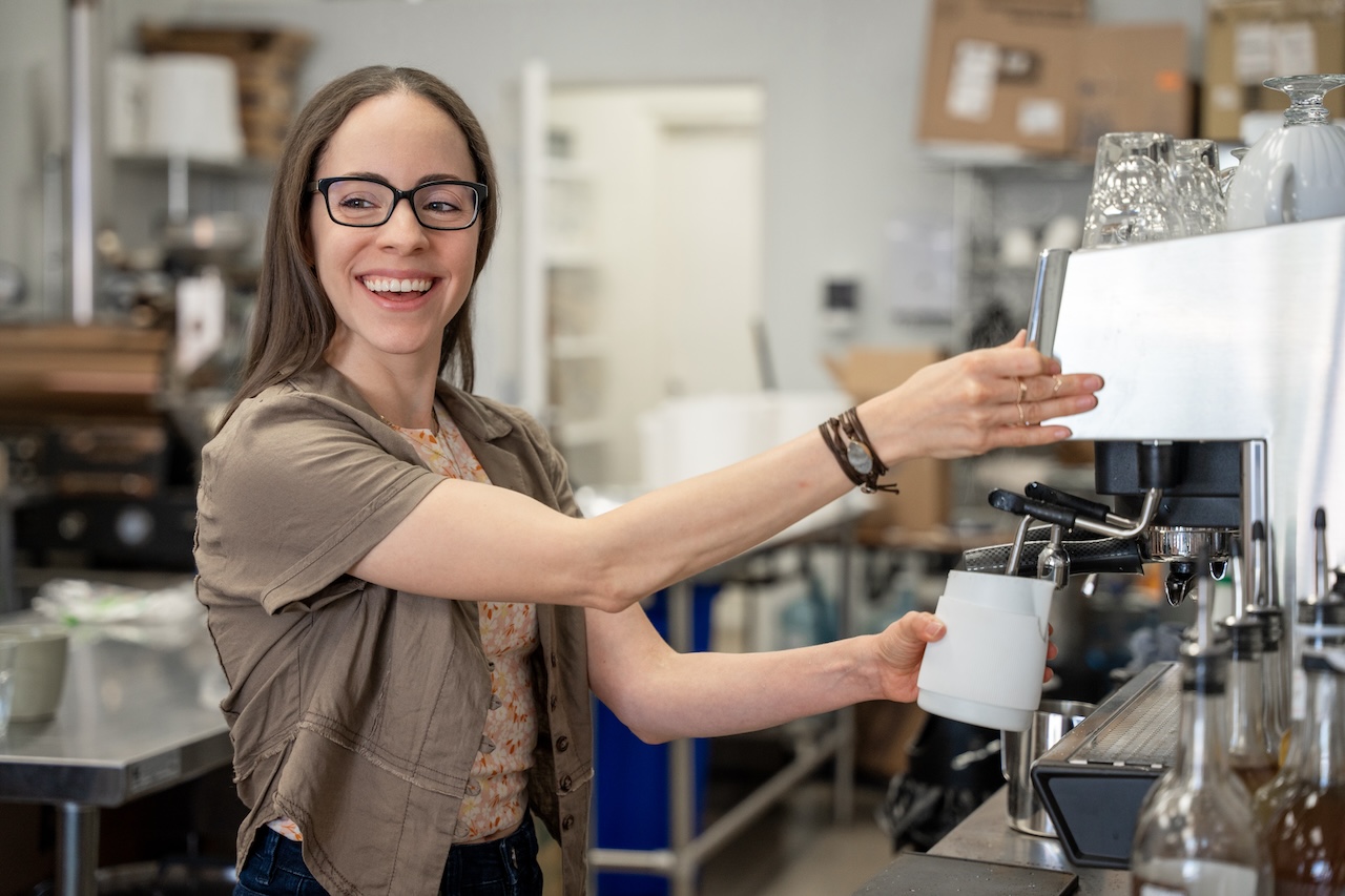 MBA alumna Denise Napolitano pouring a coffee at her cafe