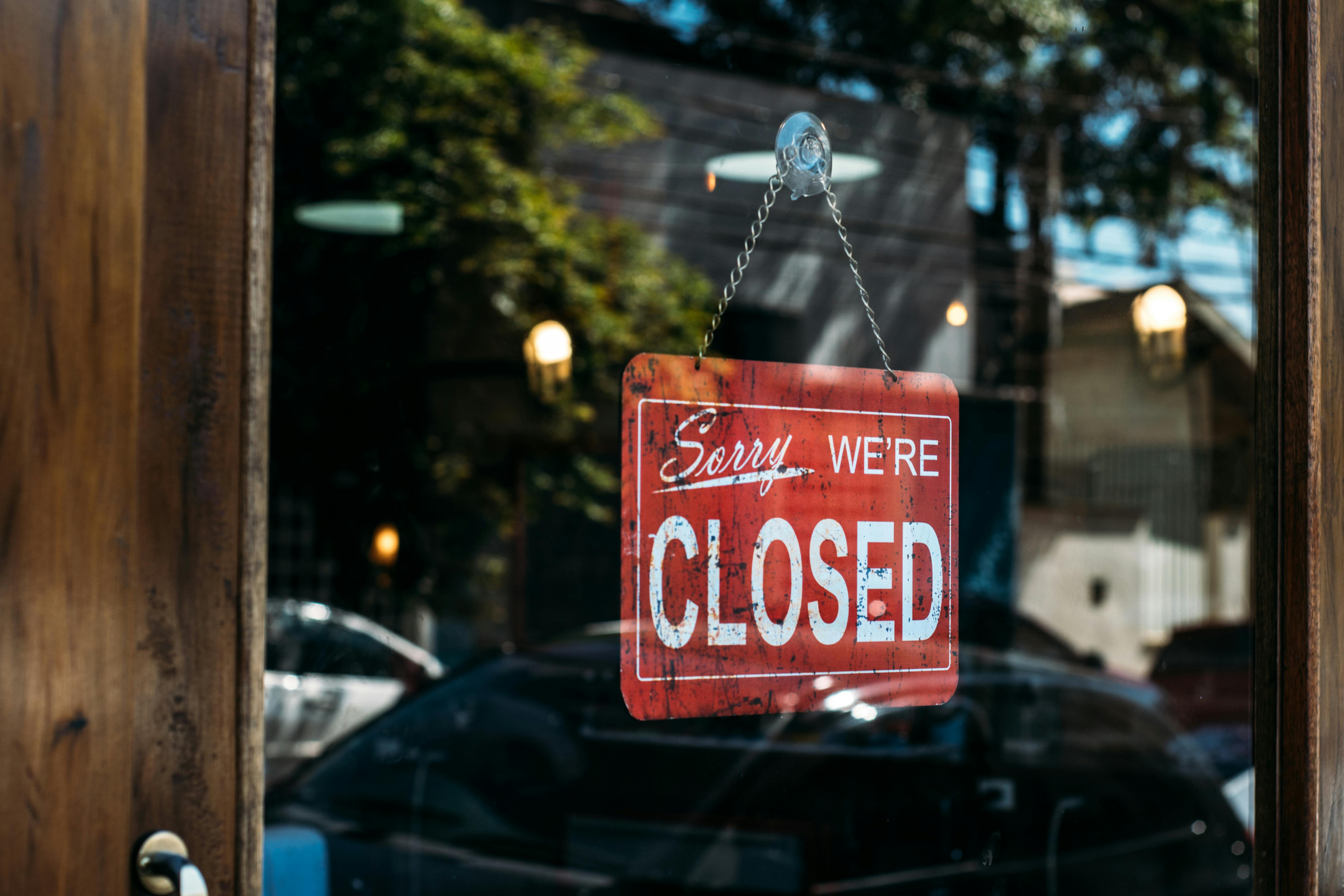 A "Sorry, we're closed" sign displayed in a window. 