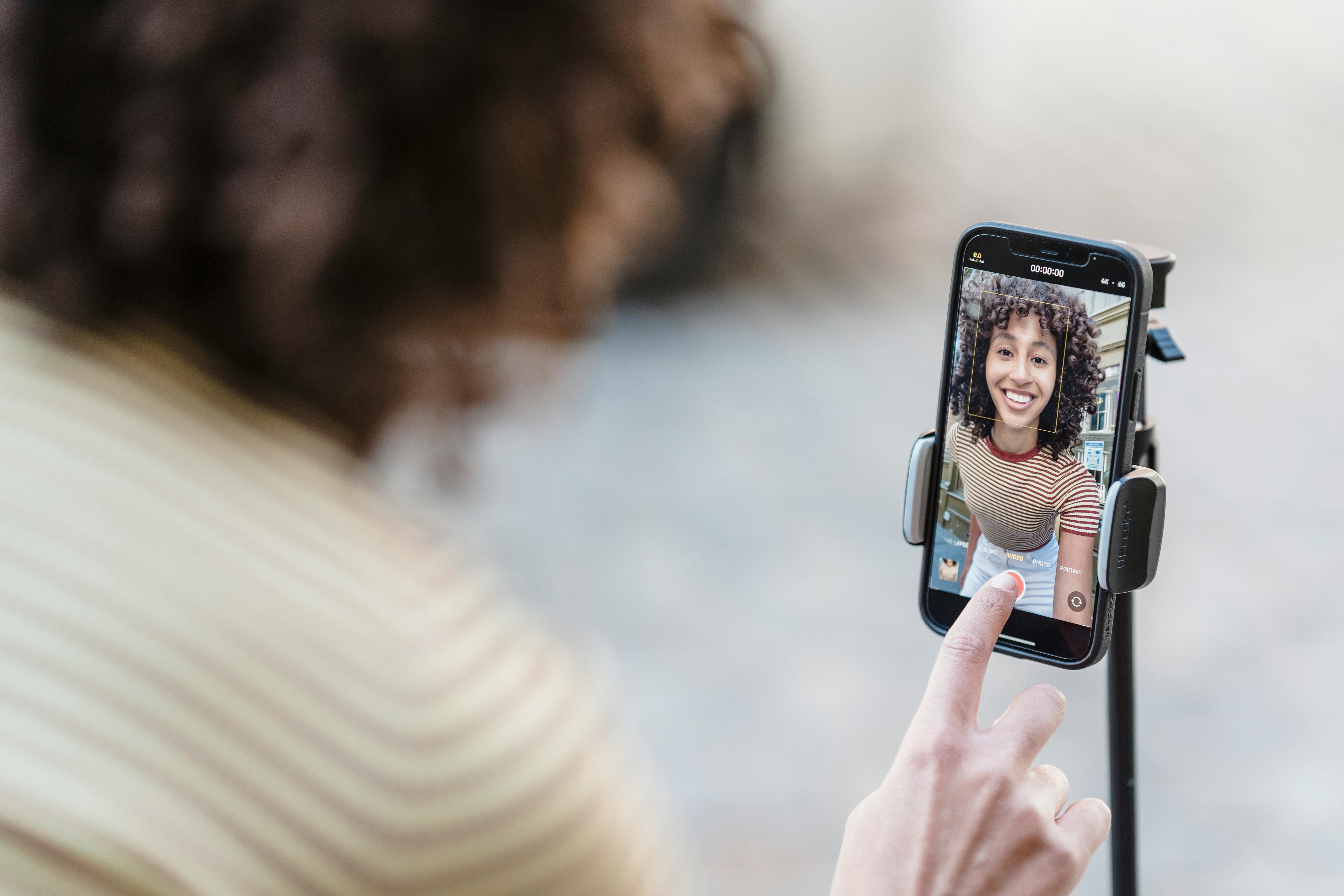 Woman filming herself on iPhone.