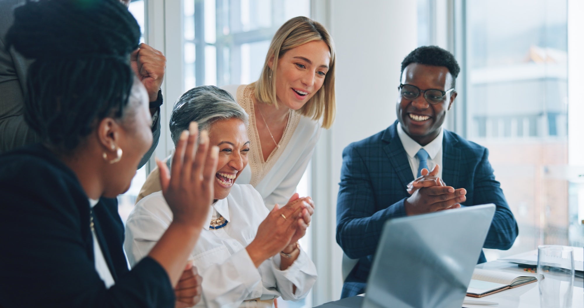 business people celebrating in front of a computer