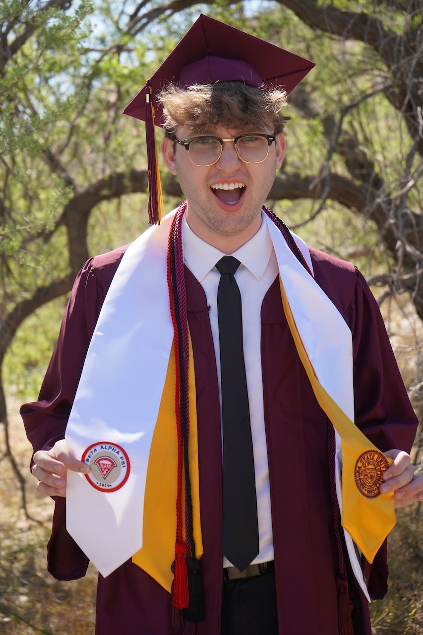 MACC student Davis Taylor in his graduation garb for a photoshoot