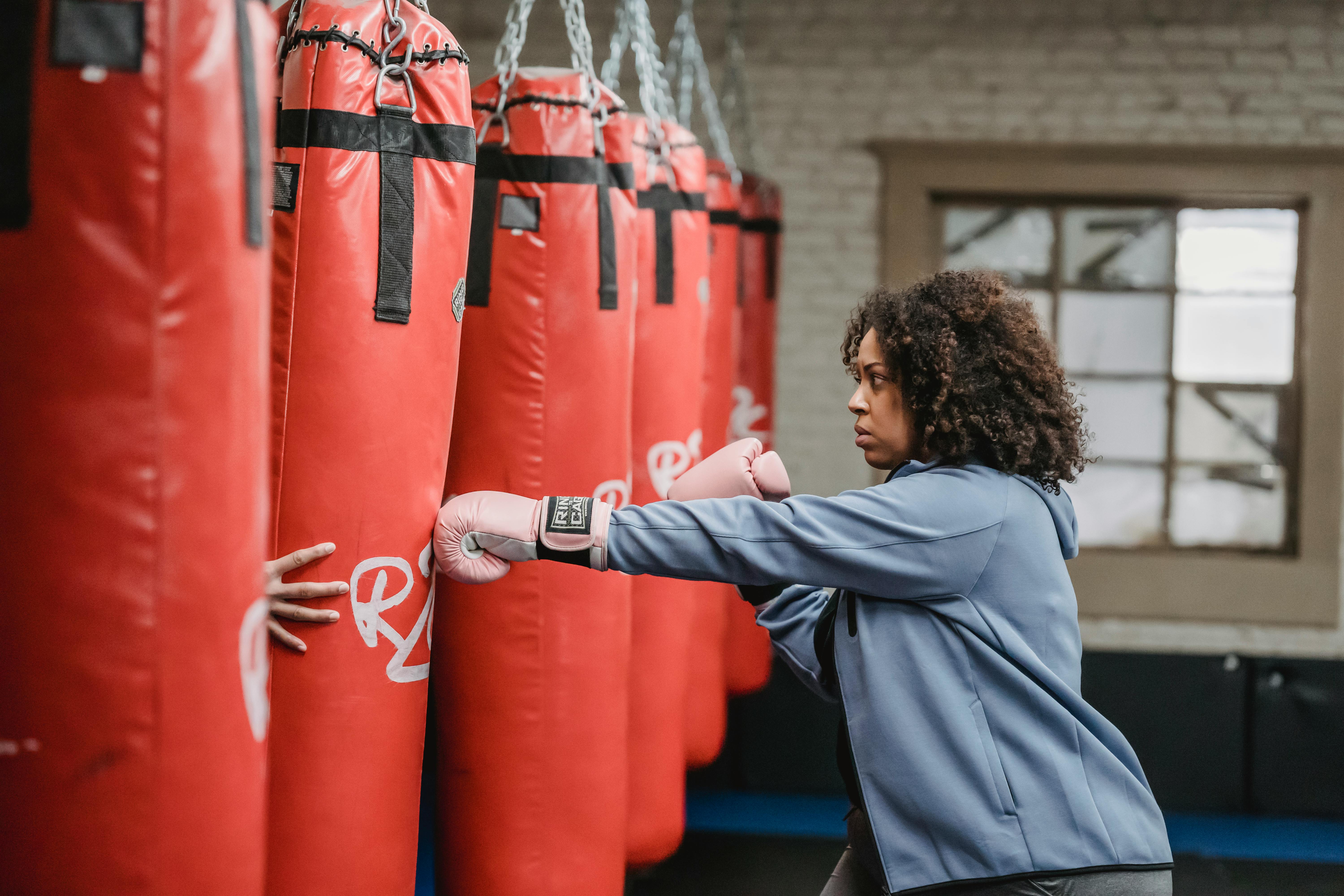 A boxing athlete practicing on a boxing bag.