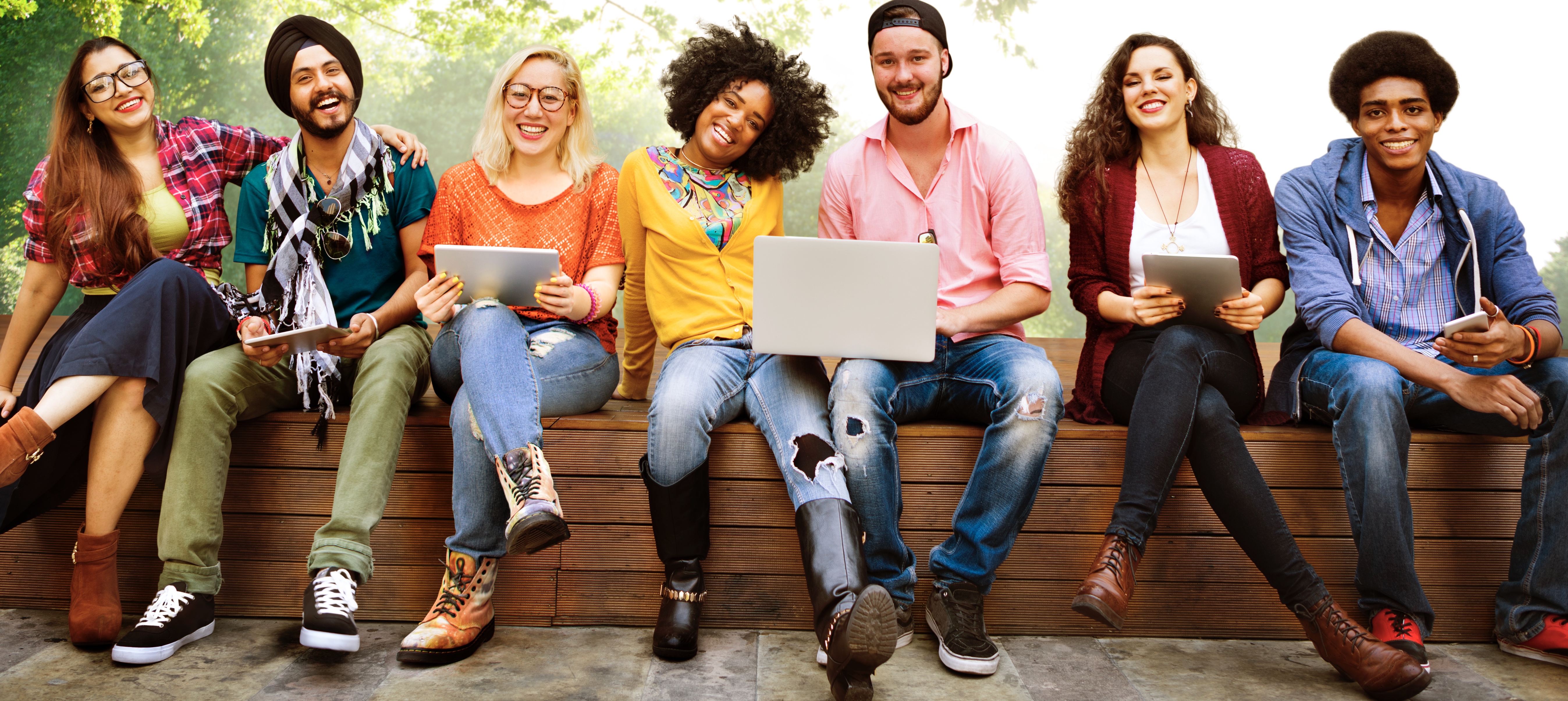 Young adults smiling using tech and collaborating