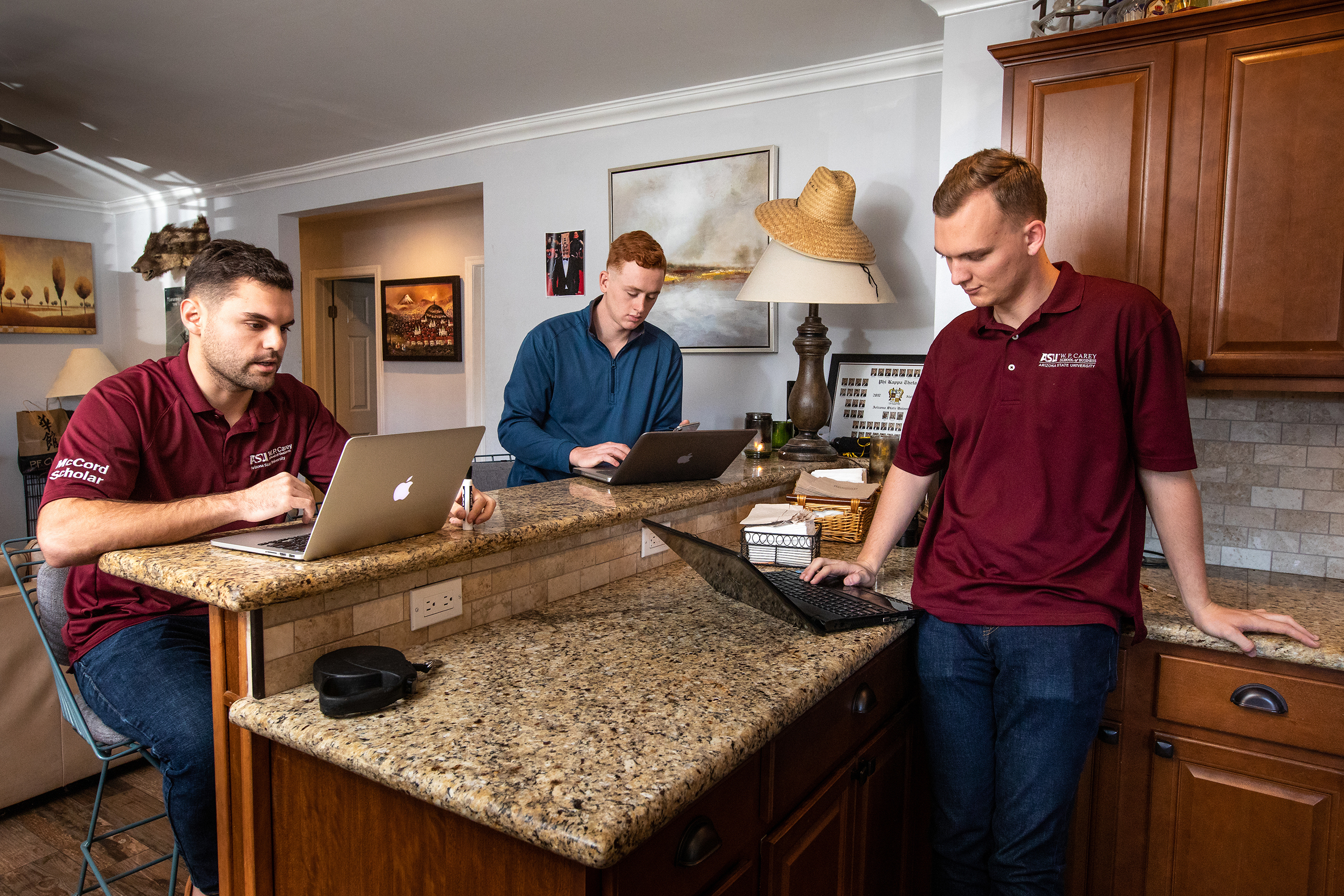 190118_triple_triple-7.jpg W. P. Carey School of Business seniors Tristan Gaynor, left, George Heiler, and Kevin Murphy, right, relax at their Tempe home before classes Friday, Jan. 18, 2019.