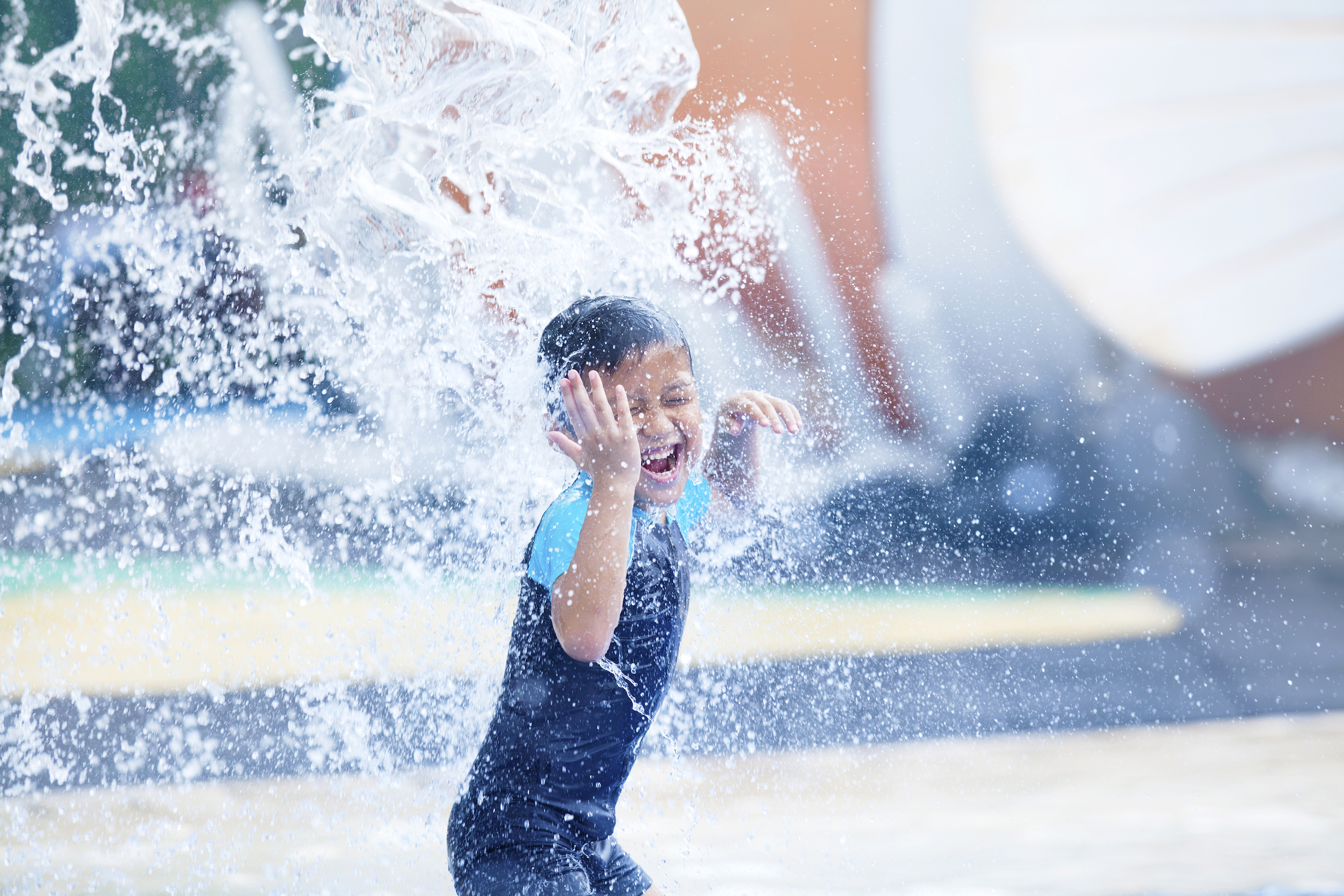 boy having fun with pool fountain