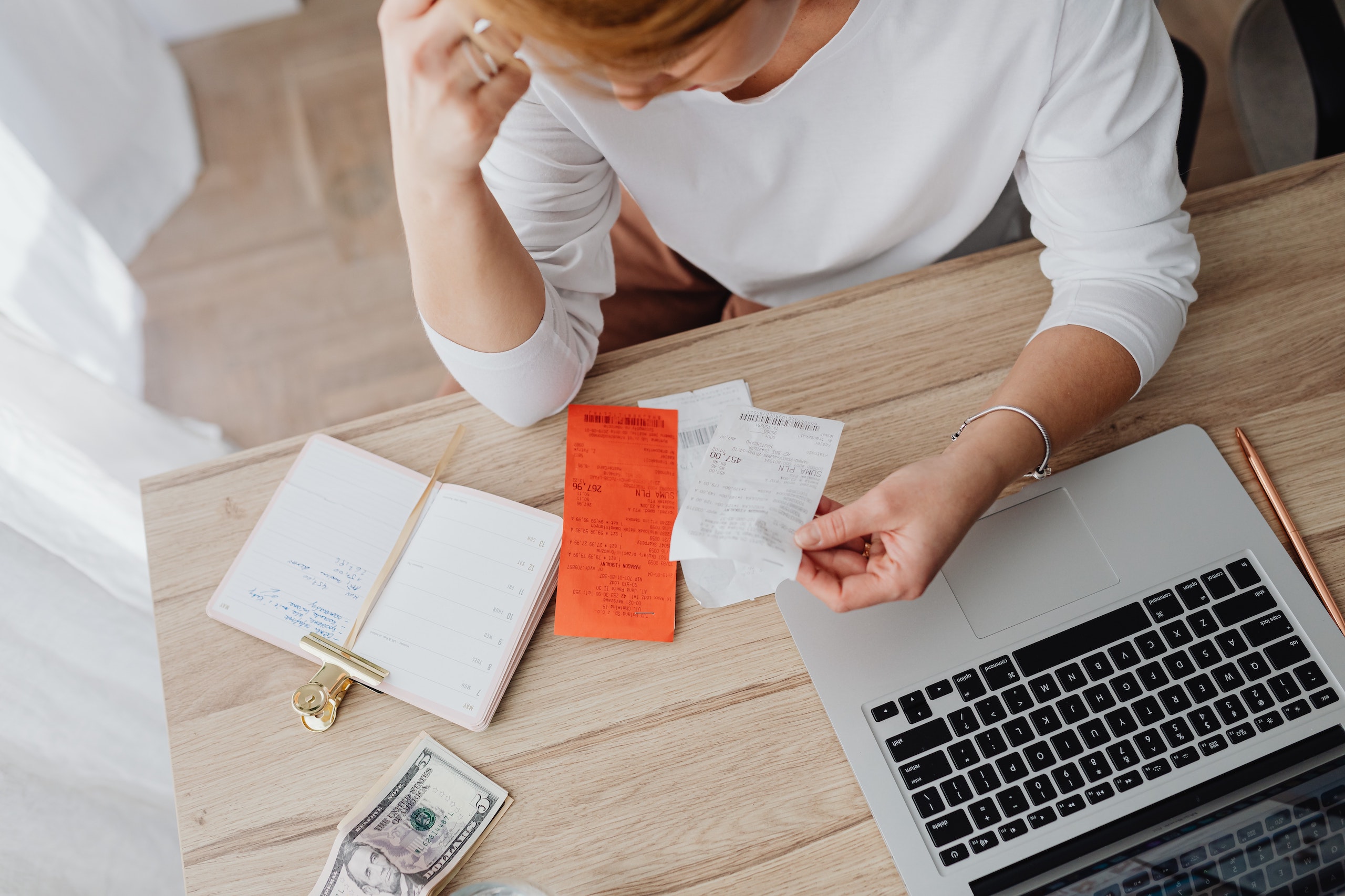 Person looking at receipts by computer
