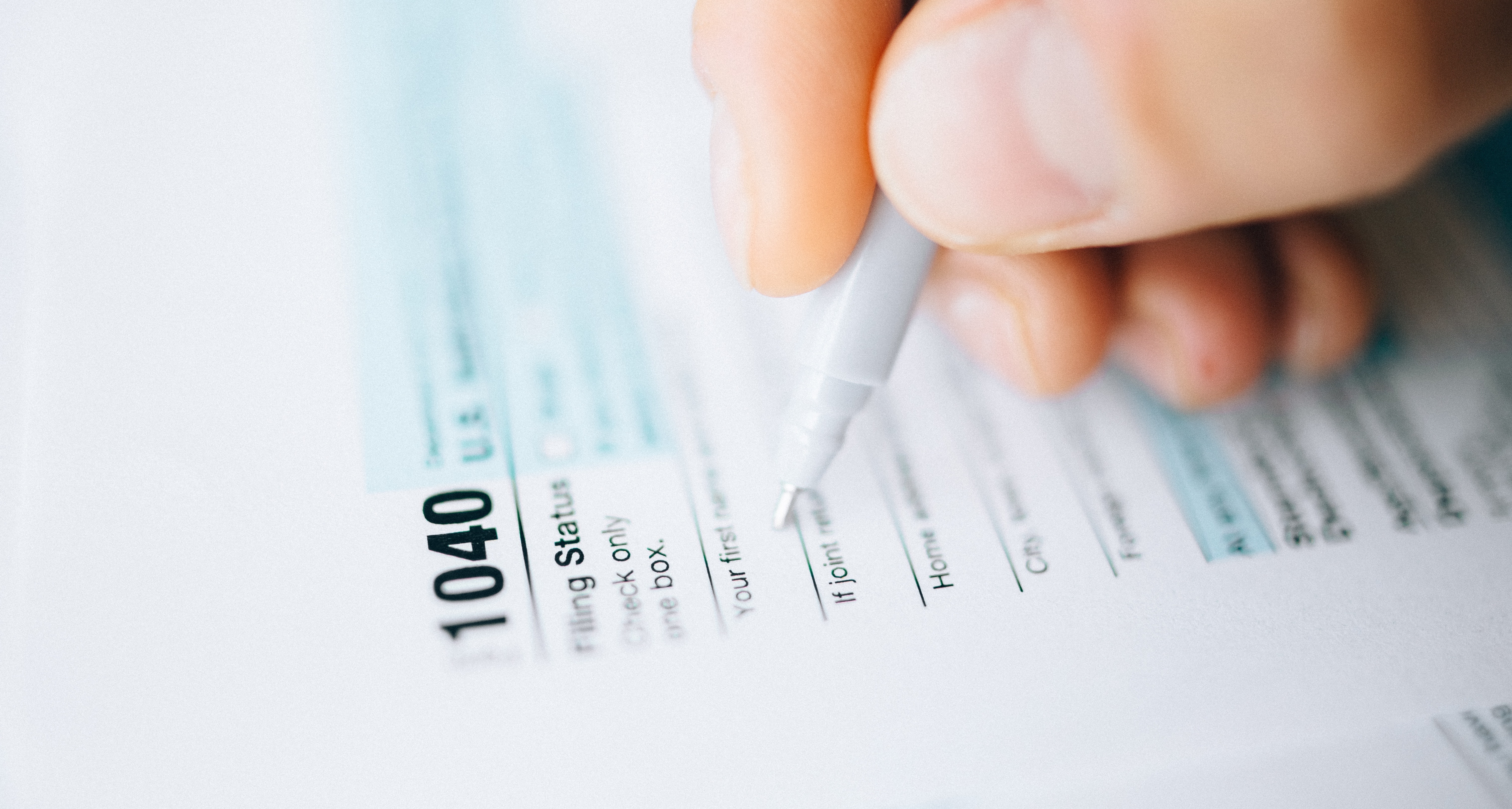 A hand filling out a tax form