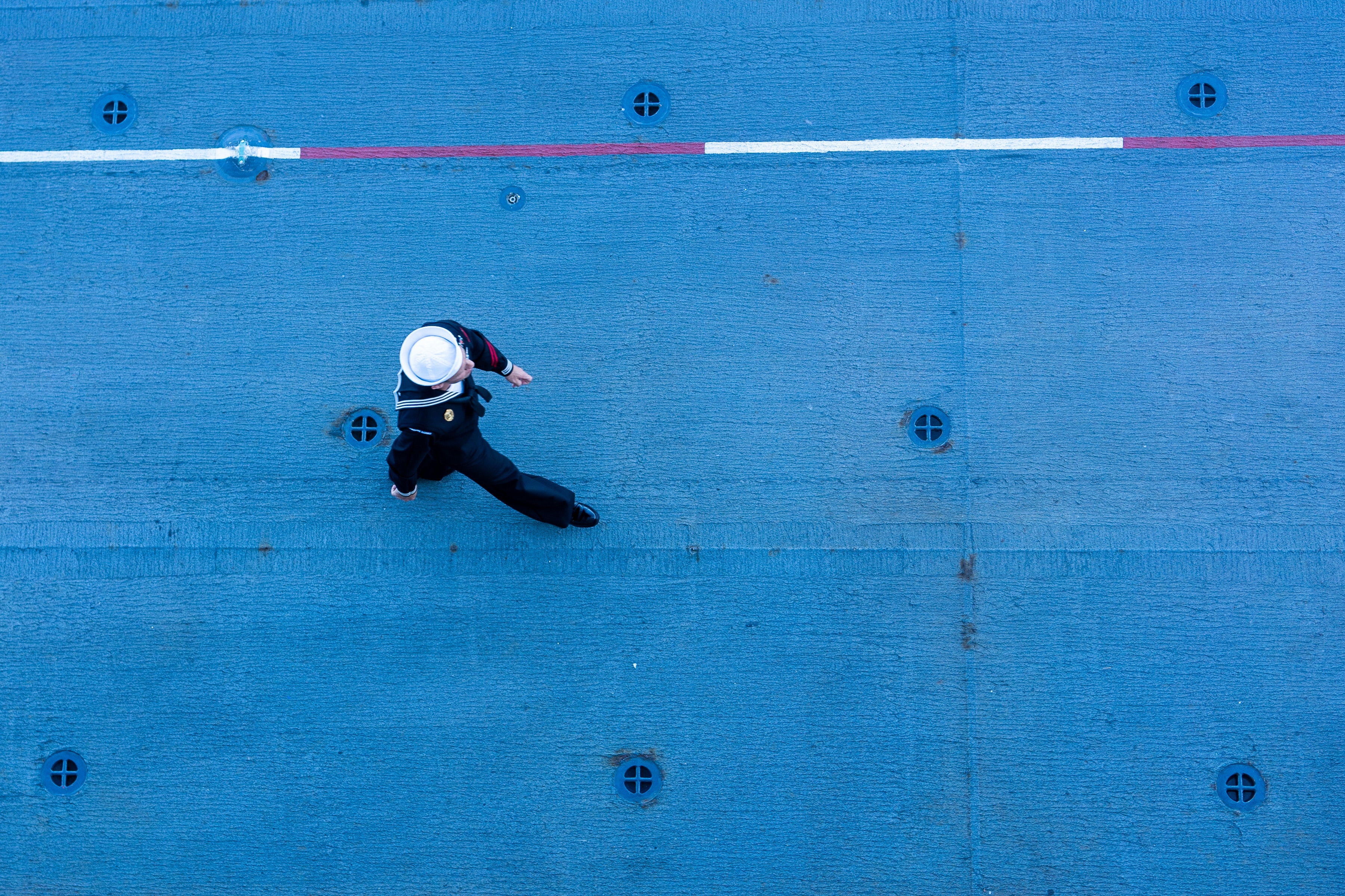 Sailor walks on boat deck.