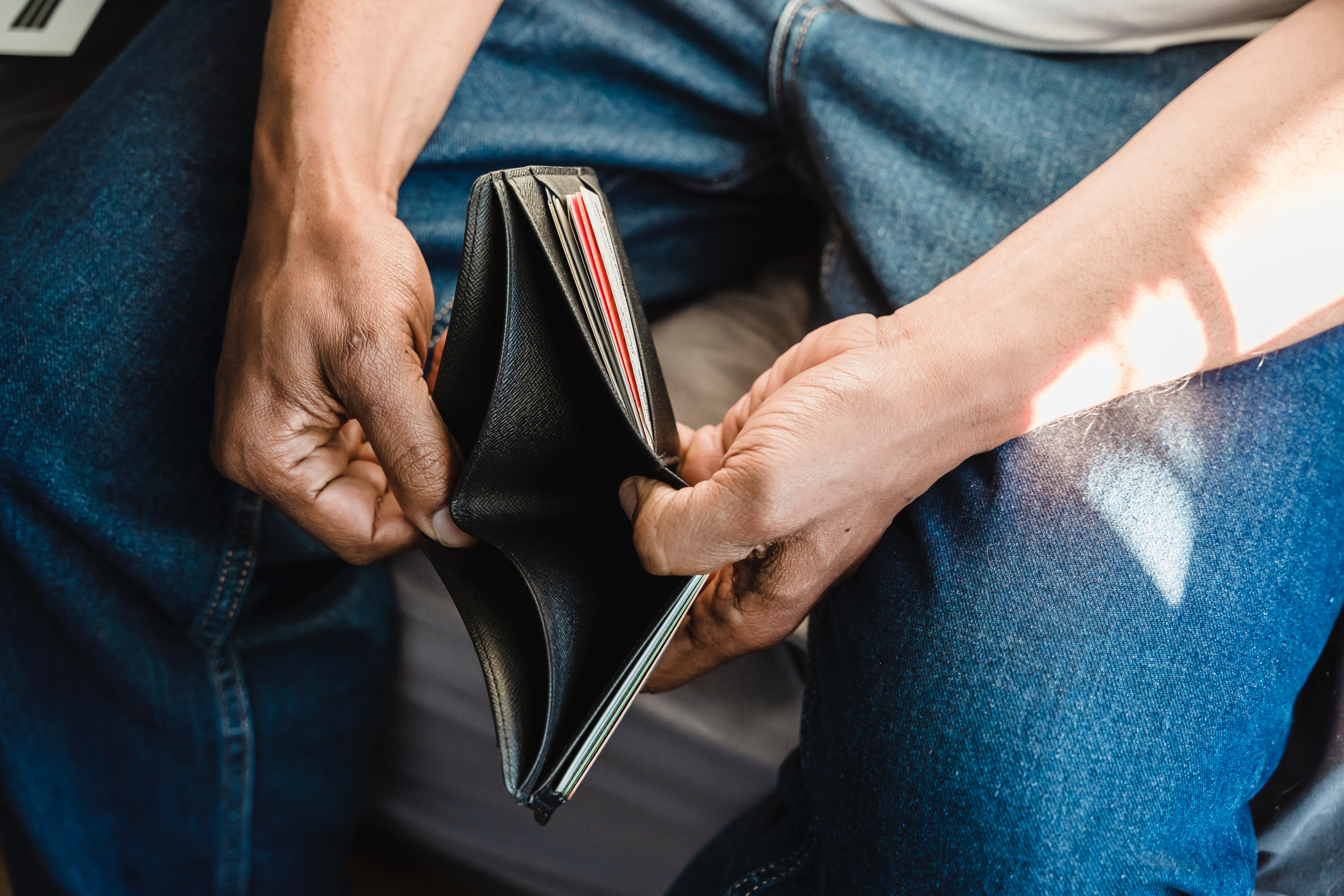 Man holds empty wallet.