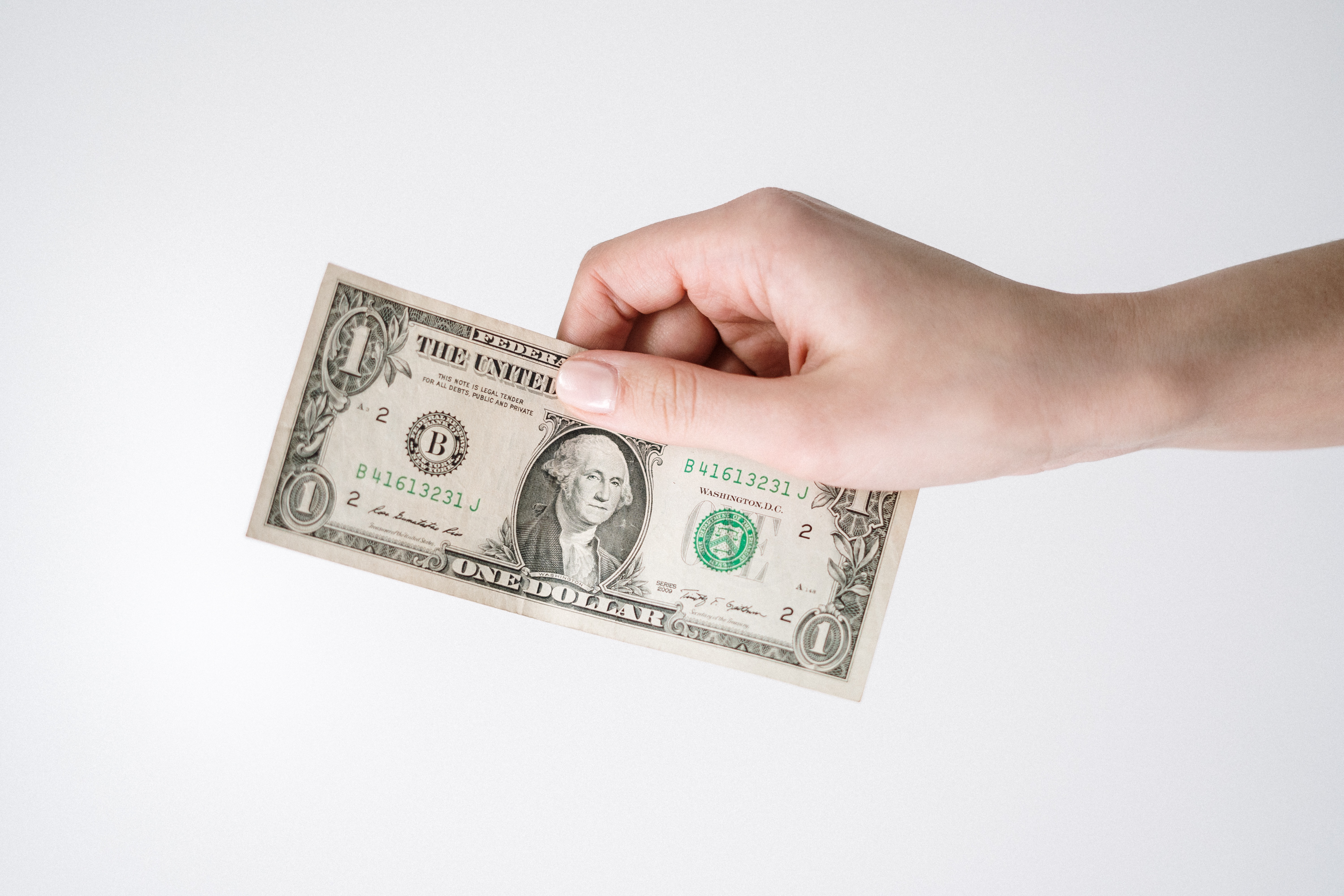 Person holding $1 bill.