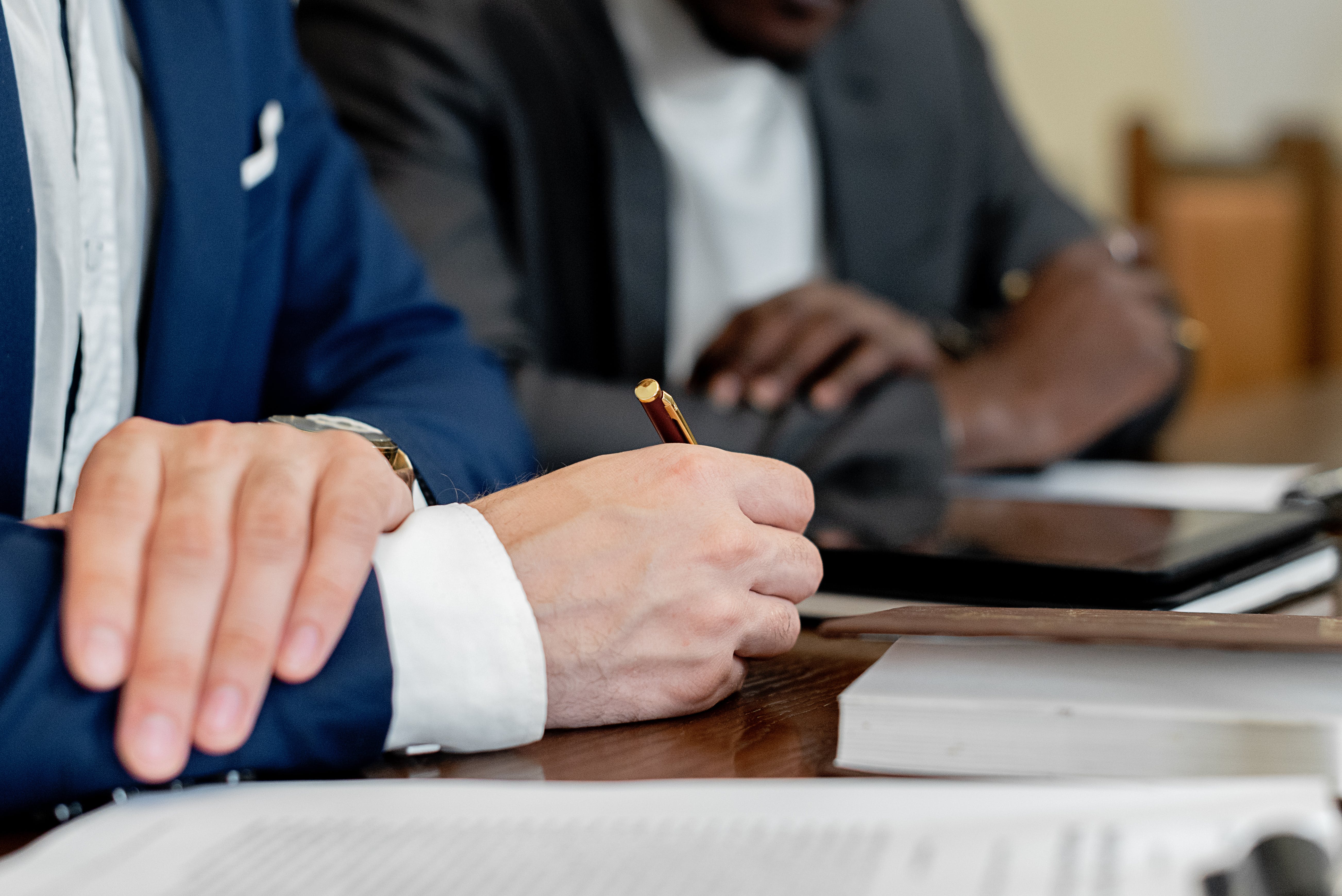 Man holding pen at table.