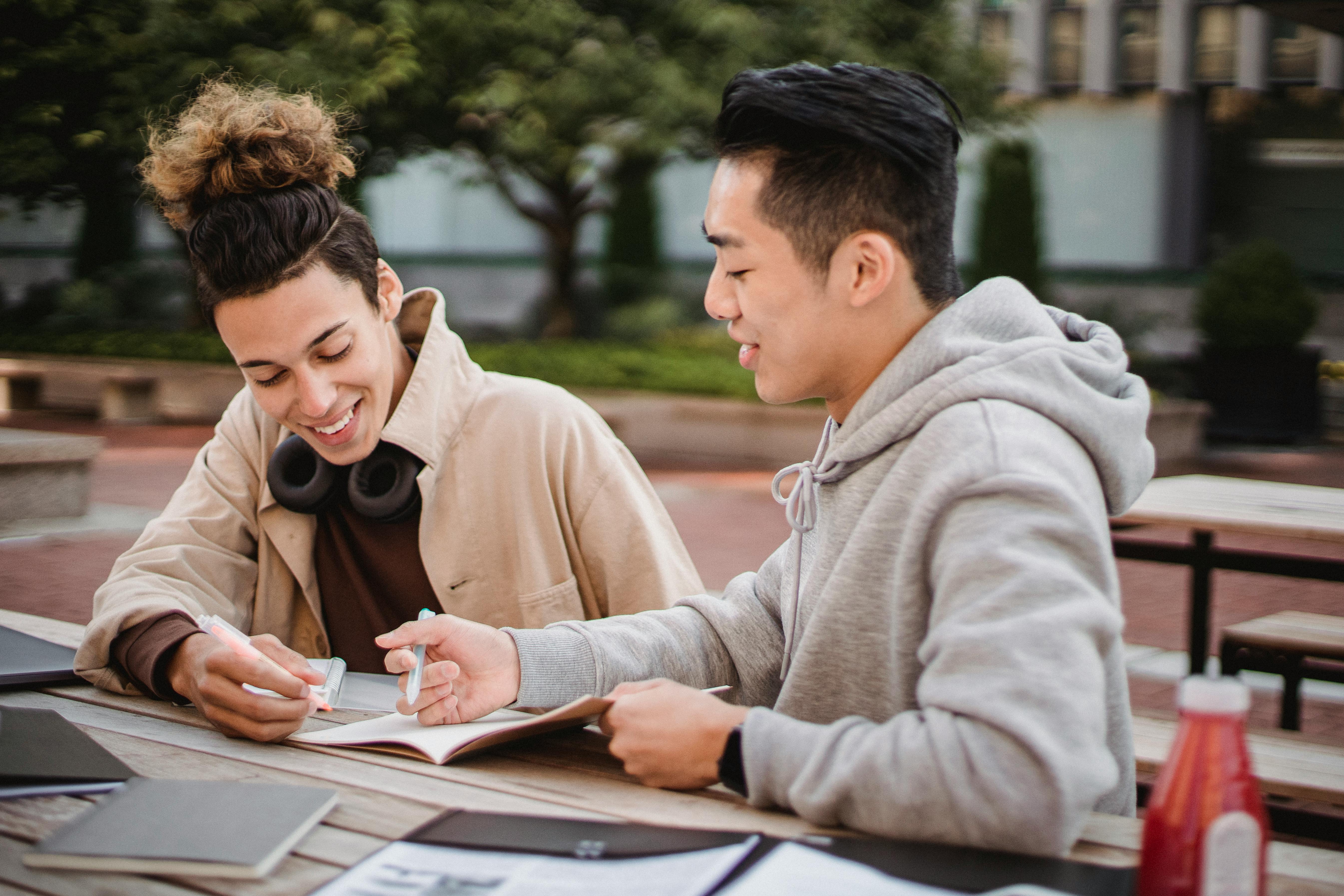 Two people looking at a notebook.