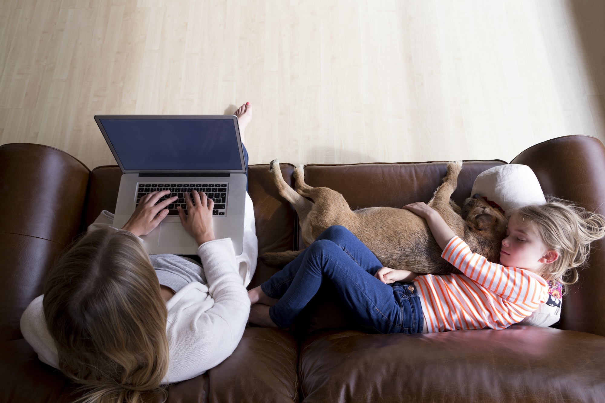 teleworking mom next to sleeping child and dog