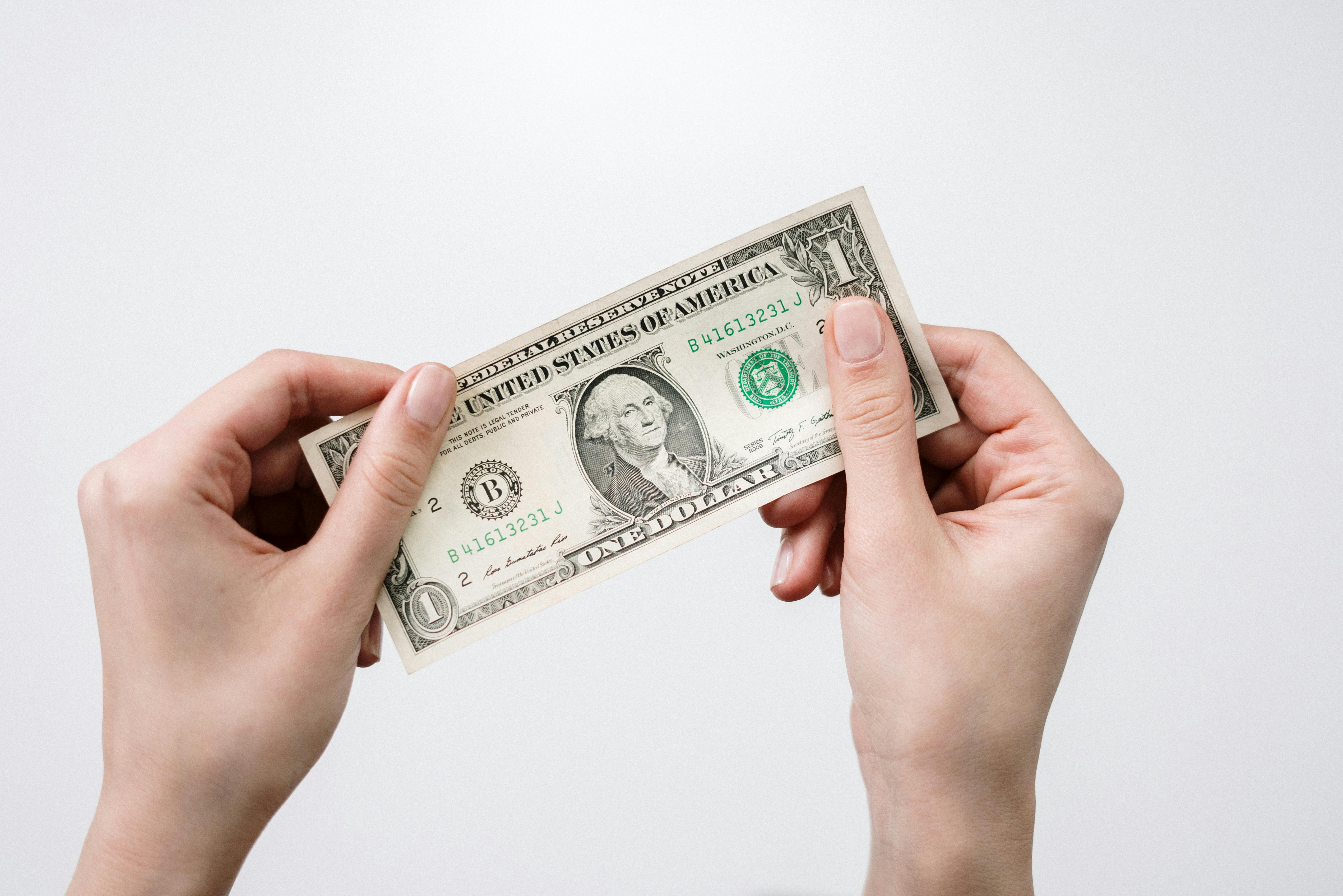Person holding a $1 bill.
